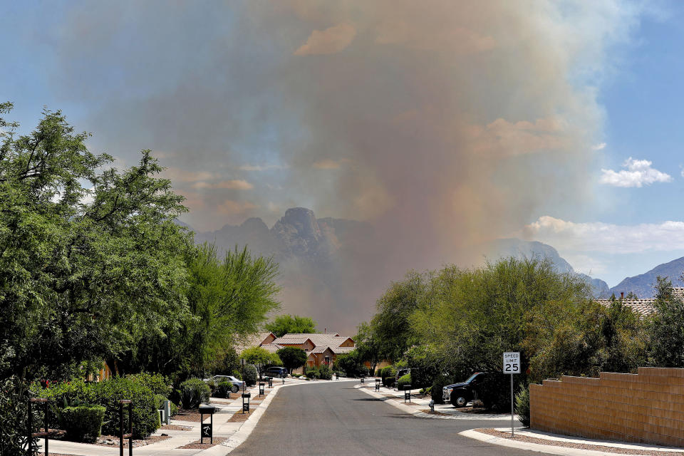 The Bighorn Fire backdrops a community along the western side of the Santa Catalina Mountains, Friday, June 12, 2020, in Tucson Ariz. Hundreds of homes on the outskirts of Tucson remain under an evacuation notice as firefighters work to keep the wildfire from moving downhill from canyons and ridges in the Coronado National Forest. (AP Photo/Matt York)