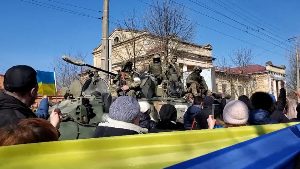 Fotografia mostra manifestantes com bandeiras ucranianas protestando em frente a um tanque de guerra