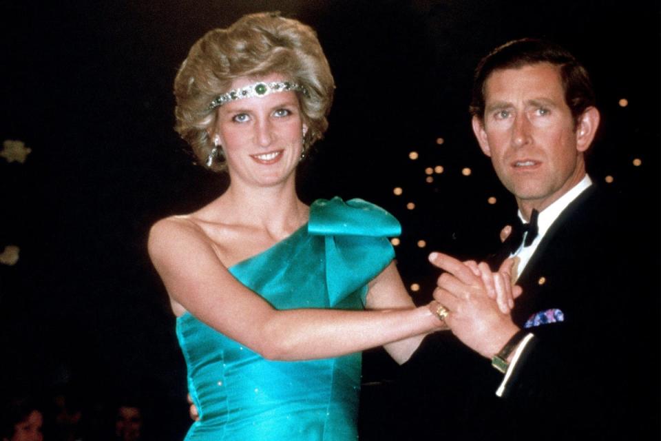 Princess Diana dances with Prince Charles while wearing a necklace as a headband (Alamy)