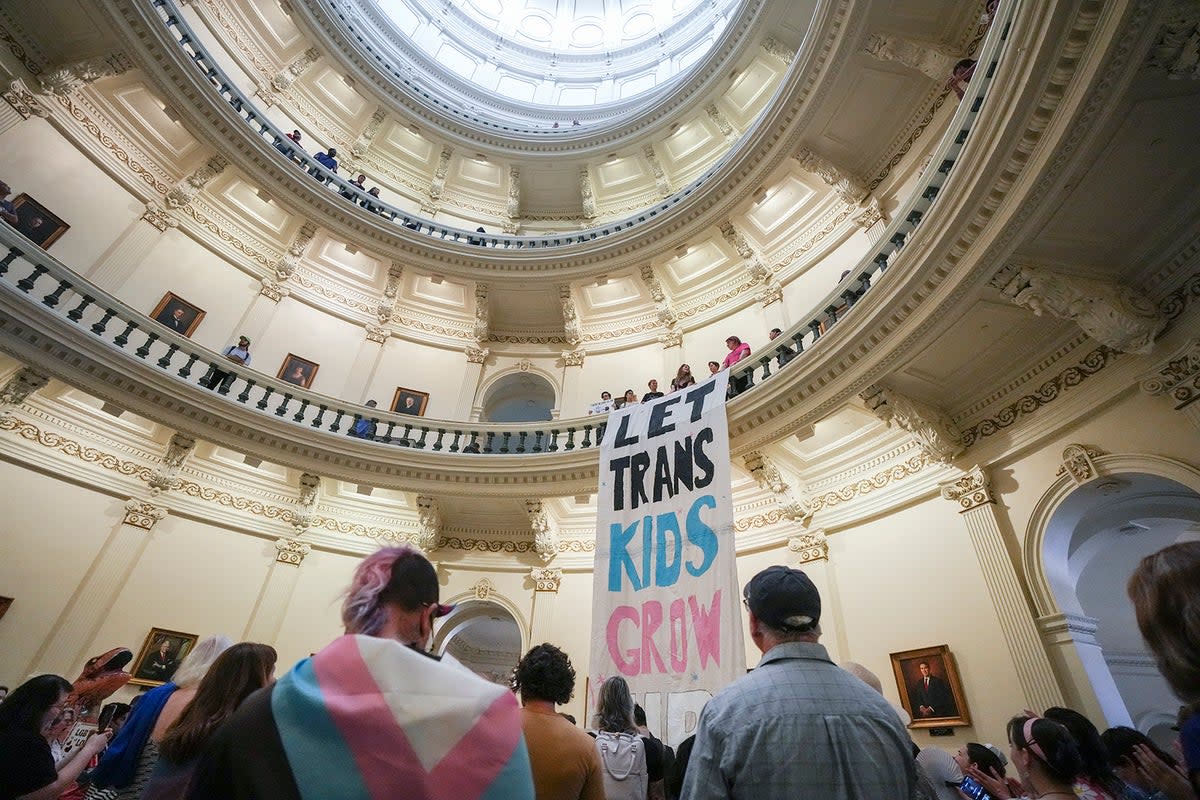 Equality Texas leadership drops a banner in the Capitol rotunda reading 