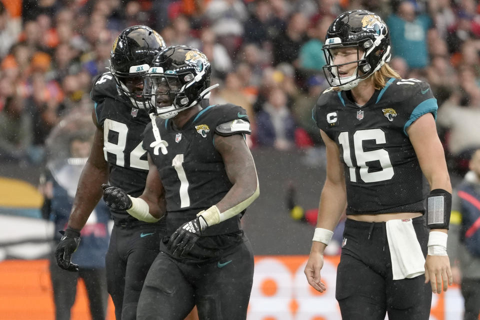 Jacksonville Jaguars running back Travis Etienne Jr. (1), and Jacksonville Jaguars quarterback Trevor Lawrence (16) and Jacksonville Jaguars tight end Chris Manhertz (84) celebrate after touchdown during the NFL football game between Denver Broncos and Jacksonville Jaguars at Wembley Stadium London, Sunday, Oct. 30, 2022. (AP Photo/Kirsty Wigglesworth)