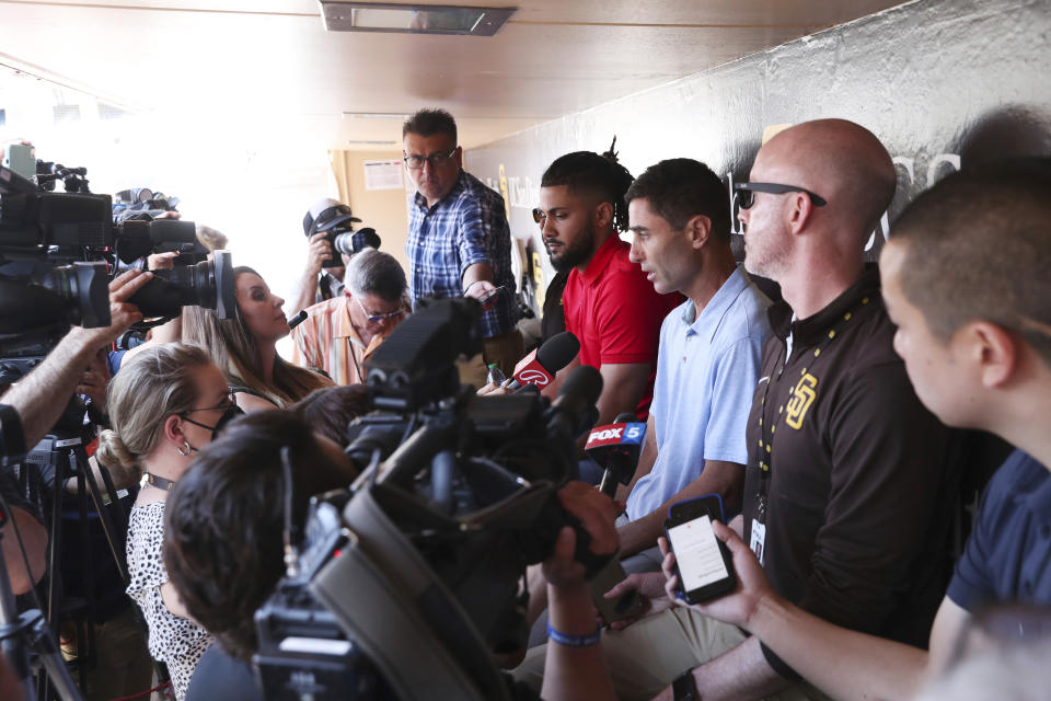 San Diego Padres' general manager A.J. Preller, third from the right, speaks with the media as Fernando Tatis Jr., fourth from the right, looks on during a press conference, Tuesday, Aug. 23, 2022, in San Diego. (AP Photo/Derrick Tuskan)