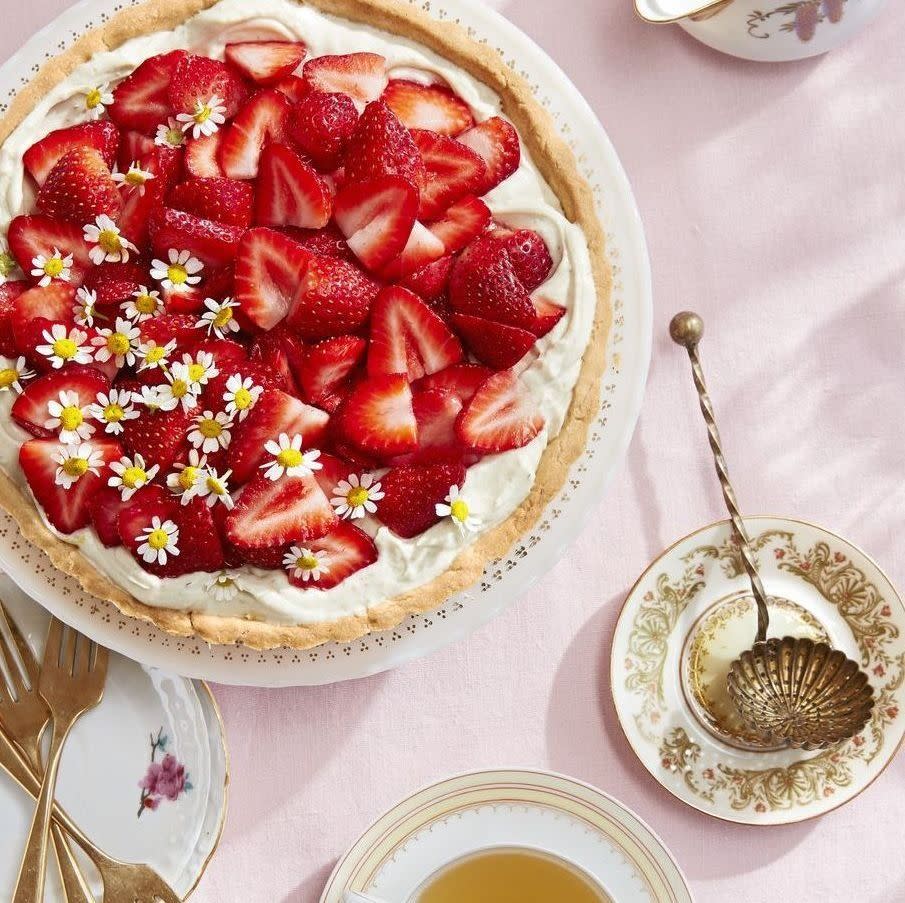 chamomile mascarpone tart topped with sliced strawberries and chamomile flowers