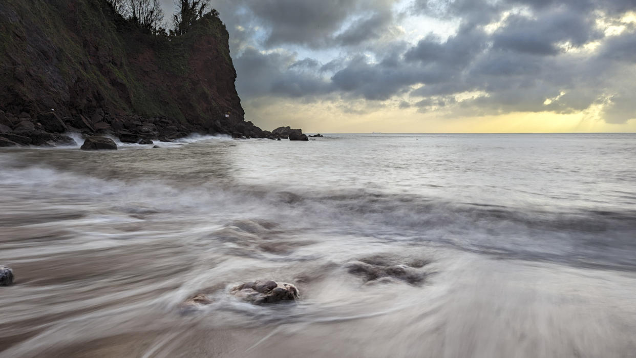  Sunrise beach with long exposure effect blurring the ocean water movement. 