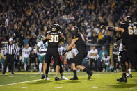 Appalachian State punter Clayton Howell (30), tight end Mike Evans (18) and place kicker Chandler Staton (91) embrace after kicking a game winning field goal during the second half of an NCAA college football game against Coastal Carolina on Wednesday, Oct. 20, 2021, in Boone, N.C. (AP Photo/Matt Kelley)