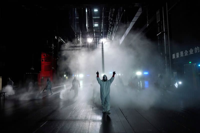 Volunteers from the Blue Sky Rescue team disinfect at the Qintai Grand Theatre in Wuhan