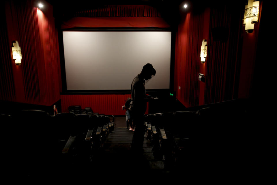 An usher looks for seats at a cinema after almost a year of theaters being closed due to the COVID-19 pandemic, in Buenos Aires, Argentina, Wednesday, March 3, 2021. (AP Photo/Natacha Pisarenko)