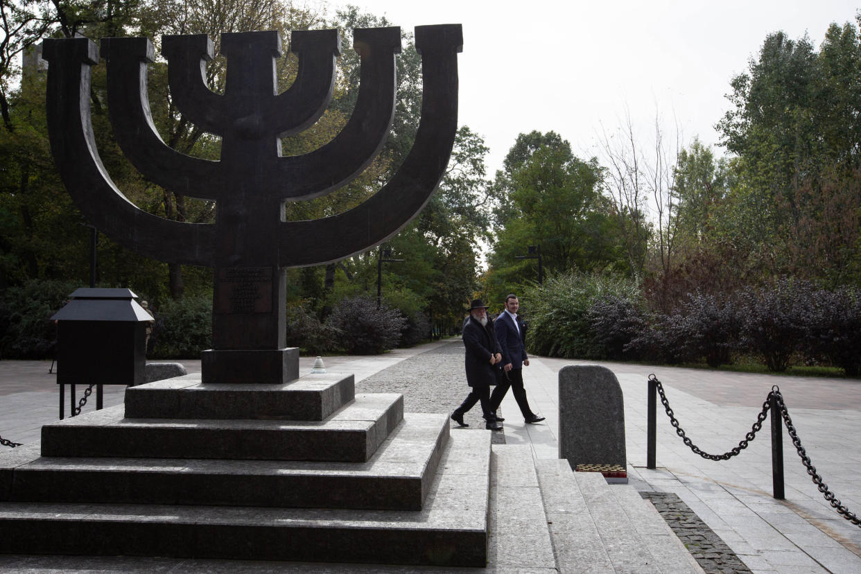 A rabbi walks past a monument commemorating the victims of Babyn Yar in Kyiv