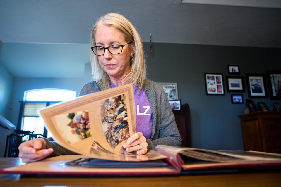 While recounting the stories behind the images, Tina Rodrigues flips through a scrapbook of family photos including photos of her late husband Kevin at the Rodrigues' Goodyear home on March 6, 2023.