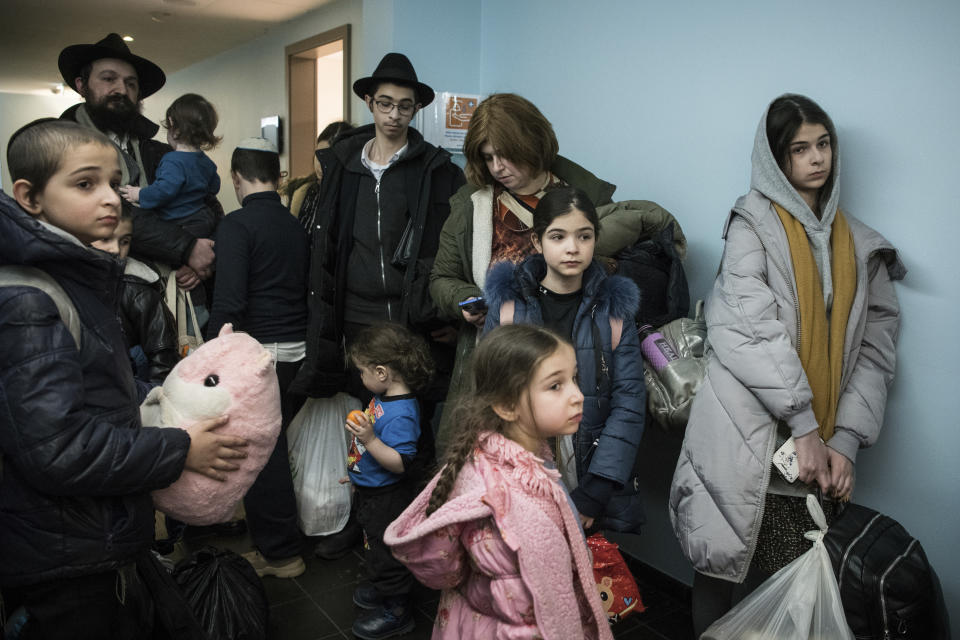 Children and their companions from an orphanage in Odesa, Ukraine, wait for room allocation after their arrival at a hotel in Berlin, Friday, March 4, 2022. More than 100 Jewish refugee children who were evacuated from a foster care home in war-torn Ukraine and made their way across Europe by bus have arrived in Berlin. (AP Photo/Steffi Loos)