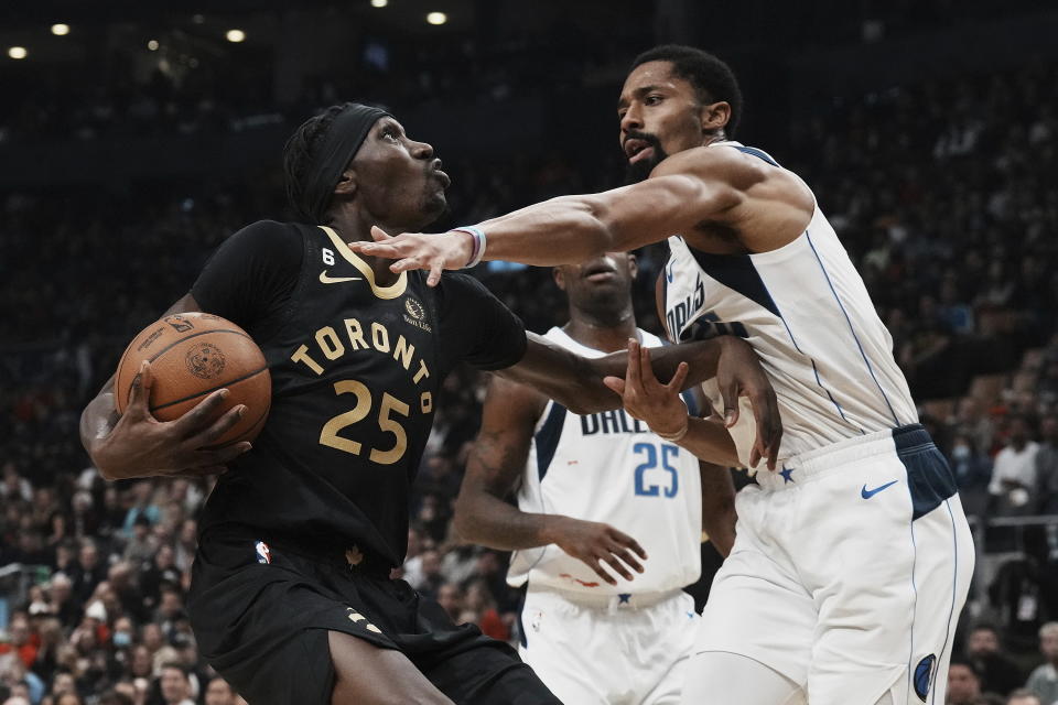 Toronto Raptors forward Chris Boucher, left, looks to the basket as he drives toward Dallas Mavericks' Spencer Dinwiddie during first-half NBA basketball game action in Toronto, Saturday, Nov. 26, 2022. (Chris Young/The Canadian Press via AP)