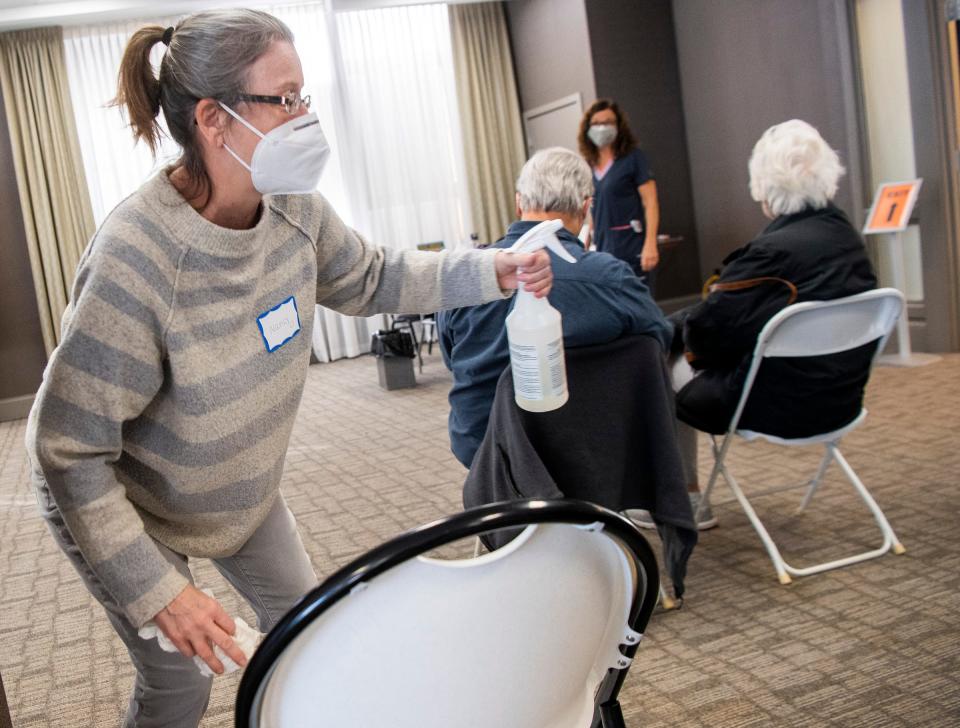 The waiting area is cleaned Wednesday after each visitor leaves at the vaccination clinic in the Monroe Convention Center. (Rich Janzaruk / Herald-Times)