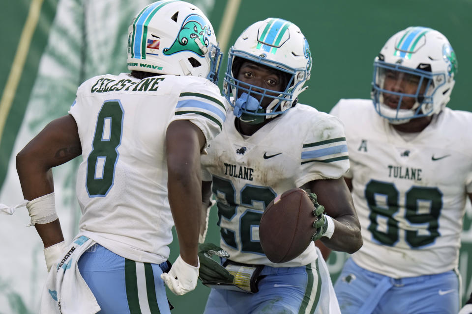 Tulane running back Tyjae Spears (22) celebrates his touchdown against South Florida with running back Iverson Celestine (8) and tight end Reggie Brown (89) during the second half of an NCAA college football game Saturday, Oct. 15, 2022, in Tampa, Fla. (AP Photo/Chris O'Meara)
