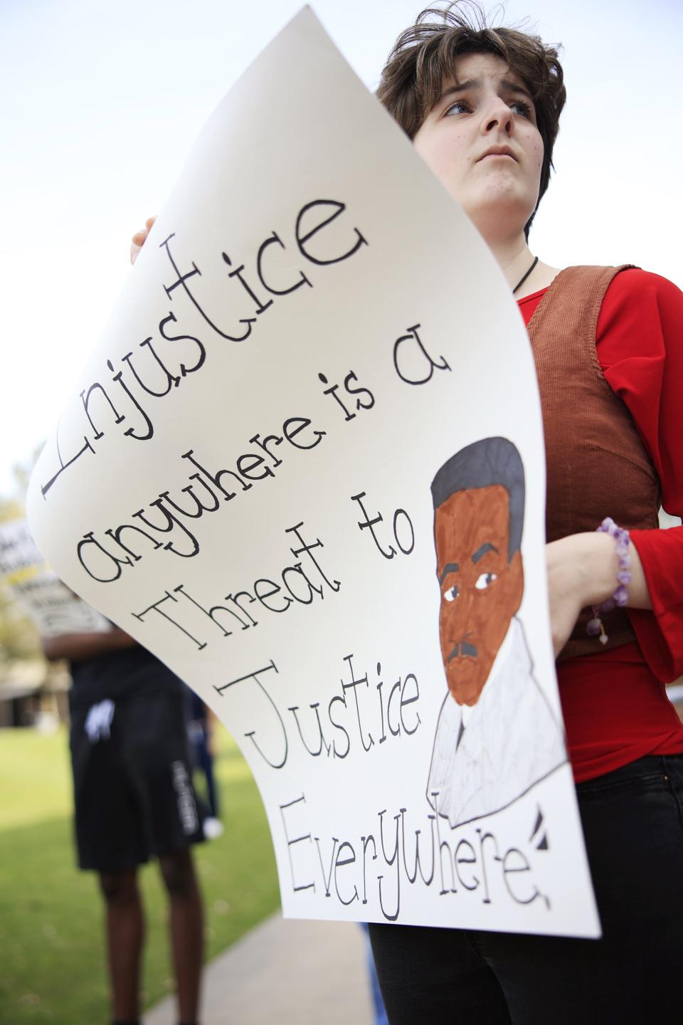 Michelle Dumars holds a sign at a Feb. 21 rally at the University of North Florida to urge protection of UNF's diversity efforts. Talking points centered around Gov. Ron DeSantis' book bans.