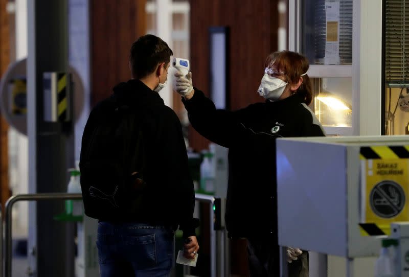 A man gets his temperature taken at Skoda Auto's factory as employees return to work after the company restarted production following a shutdown last month due to the coronavirus disease (COVID-19) outbreak in Mlada Boleslav