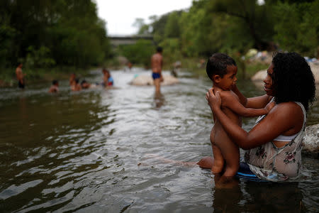 La migrante hondureña Erly Marcial, de 21 años y con ocho meses de embarazo, se da un baño en el río junto a su hijo David, de 2, en Tapanatepec, México. 6 de noviembre, 2018. REUTERS/Carlos Garcia Rawlins BUSCAR "ERLY MARCIAL" PARA ESTA HISTORIA. BUSCAR "WIDER IMAGE" PARA TODAS LAS HISTORIAS.