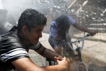 Kids cool off from the extreme heat from an opened fire hydrant in Brooklyn, New York. REUTERS/Shannon Stapleton