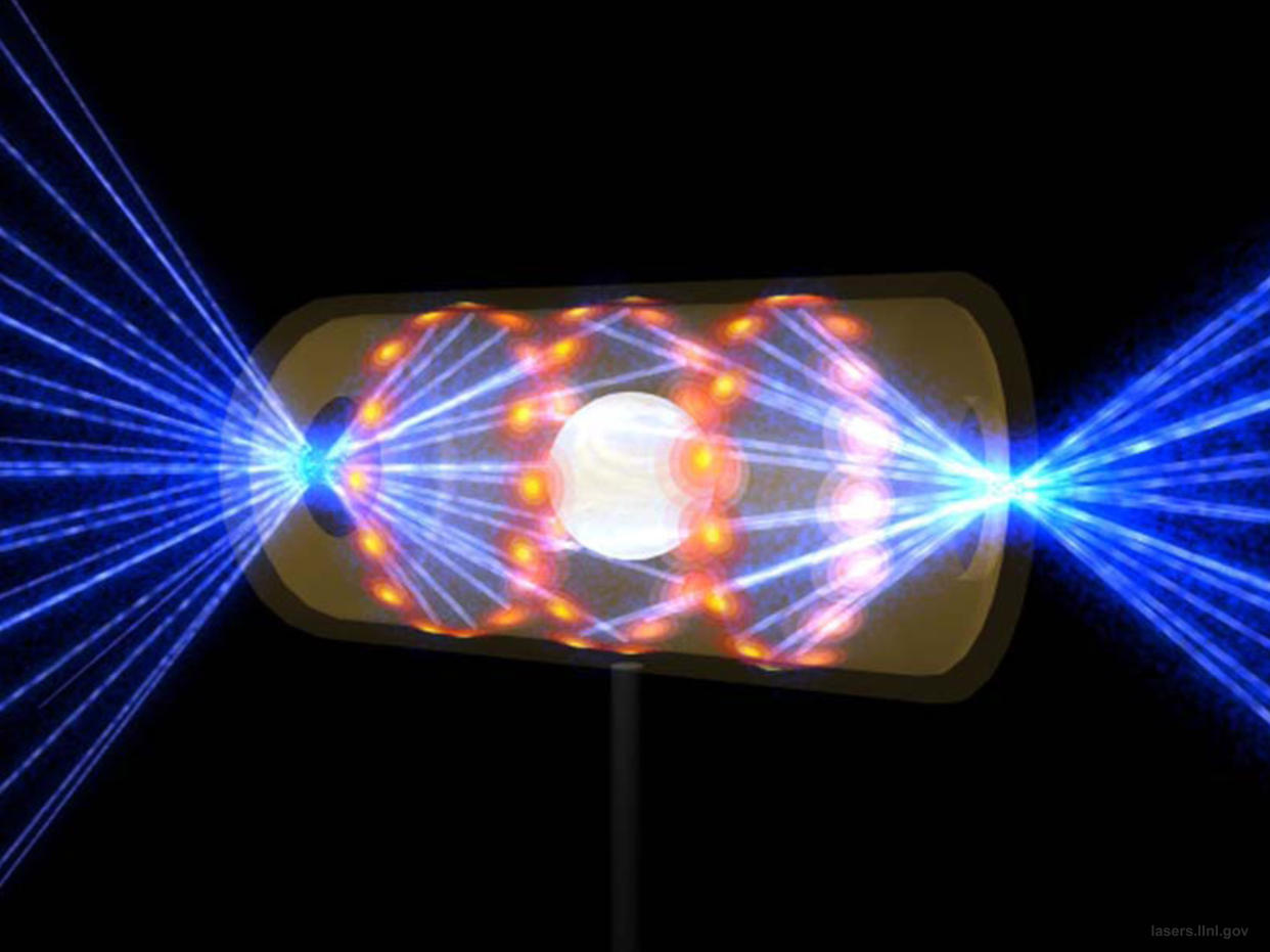 A depiction of a target pellet inside a hohlraum capsule with laser beams entering through openings on either end. 