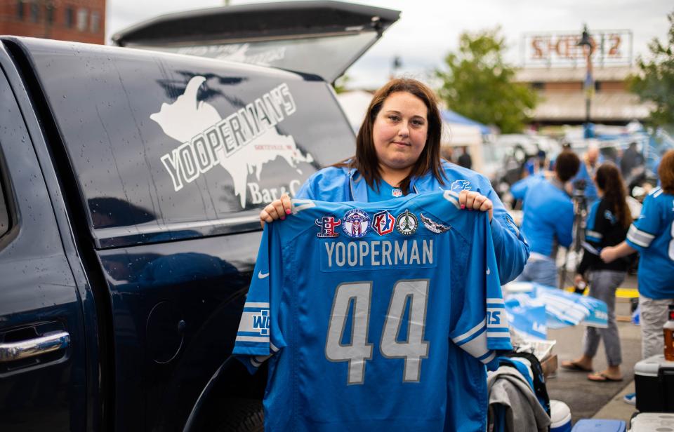 Megan Stefanski of Goetsville, Michigan holds up her late father's jersey at tailgating at the Eastern Market for the Detroit Lions' home opener, Sunday, Sept. 15, 2019. Her father Donny "Yooperman" Stefanski passed away last week. He was known for driving to Detroit every weekend from the UP to tailgate.