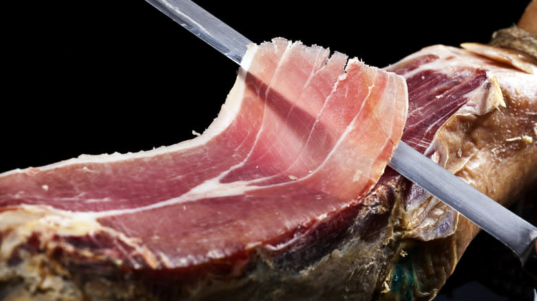Knife slicing ham