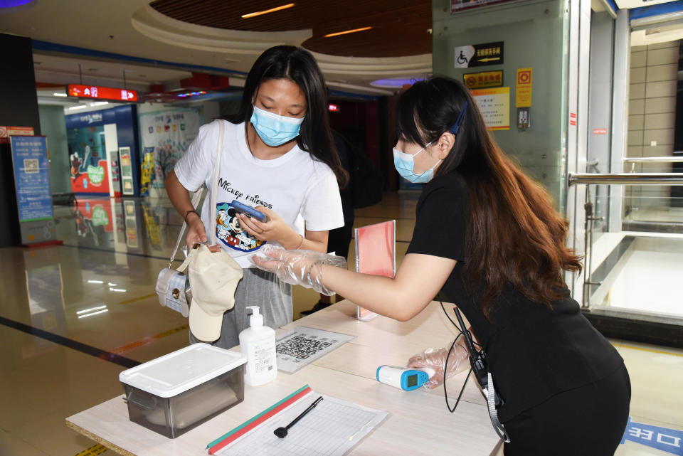 JINAN, July 20, 2020  -- An employee (R) checks a customer's health information before letting her enter a movie theater which has reopened in Jinan, east China's Shandong Province, July 20, 2020.   Some movie theaters have reopened on Monday in Jinan on the premise that proper prevention and control measures have been put into place. (Photo by Wang Kai/Xinhua via Getty) (Xinhua/Wang Kai via Getty Images)