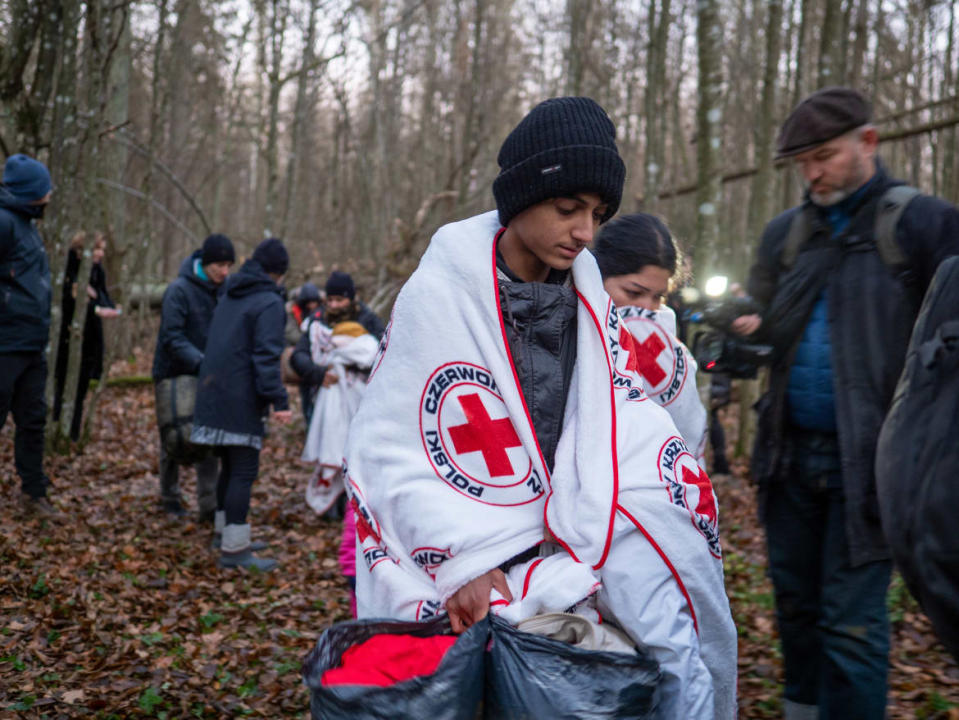 <div class="inline-image__caption"><p>NAREWKA, POLAND—Youths warm themselves with Red Cross blankets provided by Grupa Granica organization. A refugee family of 17, including nine children from Dohuk, Iraq, spent 17 days in a forest on Belarus-Polish border.</p></div> <div class="inline-image__credit">Jana Cavojska/SOPA Images/LightRocket via Getty Images</div>