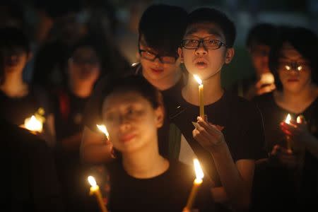 People sing a song by Hong Kong band Beyond during a candlelight vigil in solidarity with protesters of the "Occupy Central" movement in Hong Kong, at Hong Lim Park Speakers' Corner in Singapore October 1, 2014. REUTERS/Edgar Su