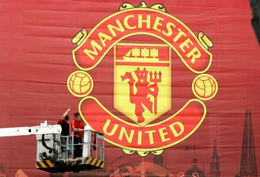 Workmen adjust a large Manchester United banner at Moscow's Luzhniki stadium in 2008. Legendary British football club Manchester United, overloaded with debt since their takeover by a billionaire American family of investors, is moving to raise cash through a US share sale