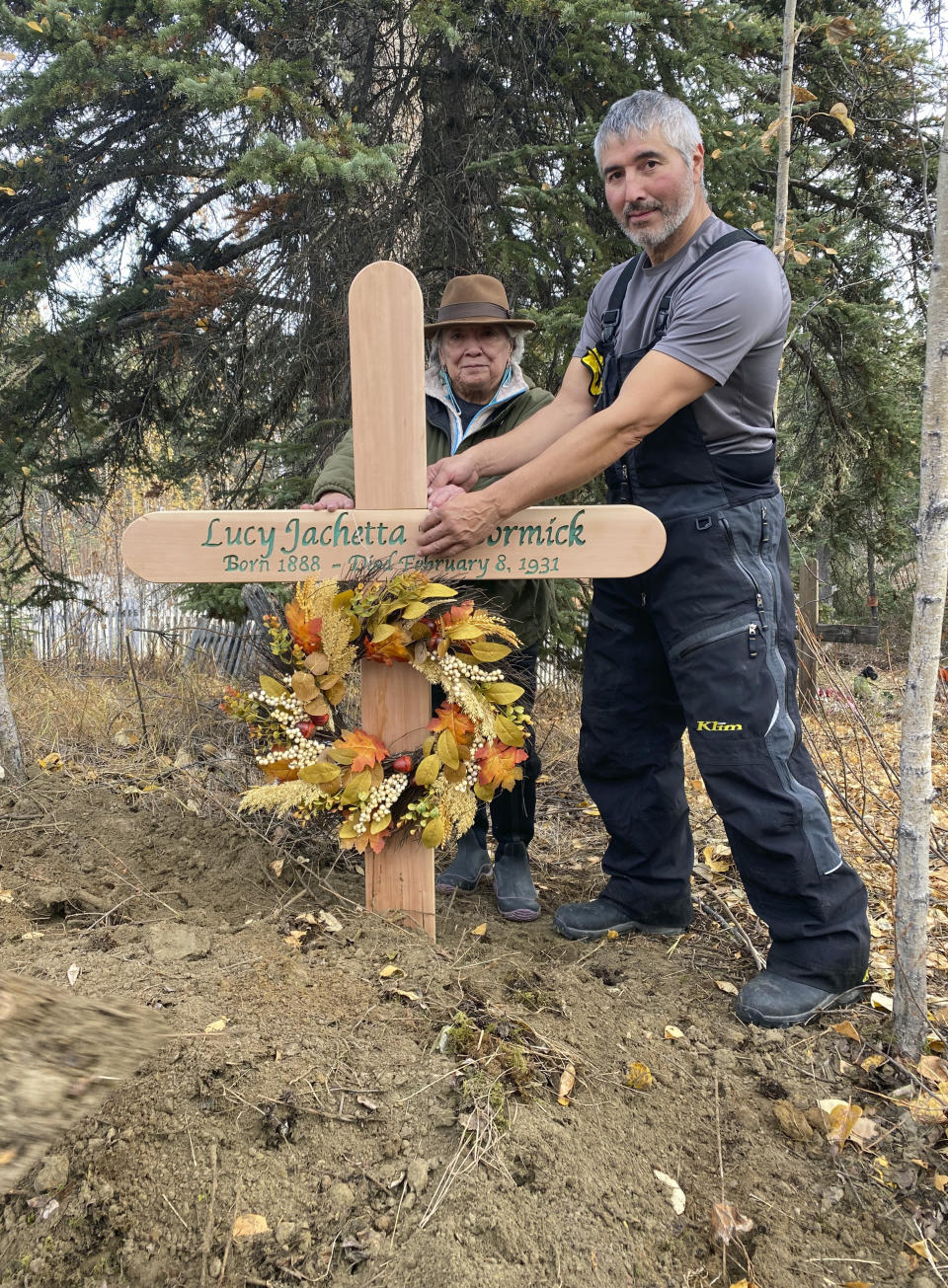 In this Sept. 29, 2023, photo, Brian Cruger holds the cross made for the grave of his great-grandmother, Lucy Pitka McCormick, and with him is McCormick's granddaughtger, Kathleen Carlo, during a reburial ceremony in Rampart, Alaska. Pitka was one of the Lost Alaskans sent to a mental hospital in the 1930s. Her grave was recently discovered, and family members brought her back to Alaska for a proper burial. (Photo by Wally Carlo via AP).