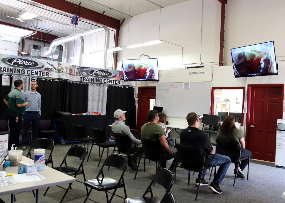 People watch training videos at the Pierce hiring event on Thursday, May 19, 2022.