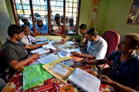 FILE PHOTO: People wait to check their names on the draft list at the National Register of Citizens (NRC) centre at a village in Nagaon district