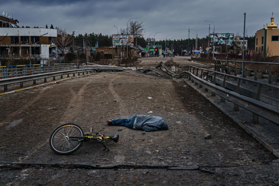 A dead body is seen on the ground on the destroyed bridge in Irpin. 