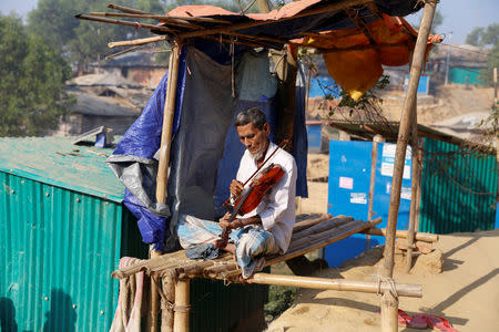 Amir Ali, 75, plays a violin in front of his house in Kutuapalong Rohigya refugee camp in Cox’s Bazar, Bangladesh, February 8, 2019. Picture taken February 8, 2019. REUTERS/Jiraporn Kuhakan