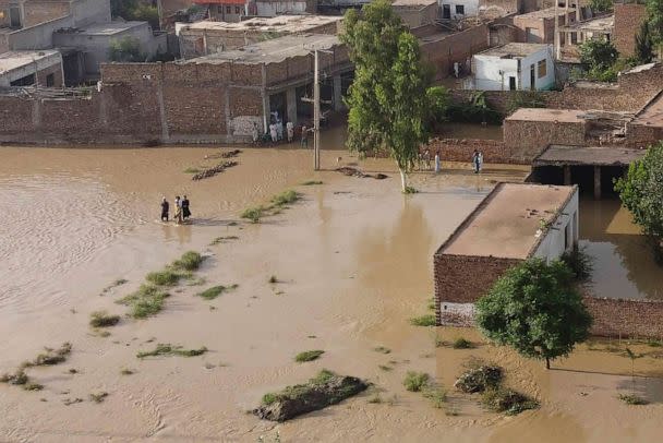 PHOTO: Residents wade through a flood hit area following heavy monsoon rains in Charsadda district of Khyber Pakhtunkhwa, Aug. 29, 2022. (Abdul Majeed/AFP via Getty Images)