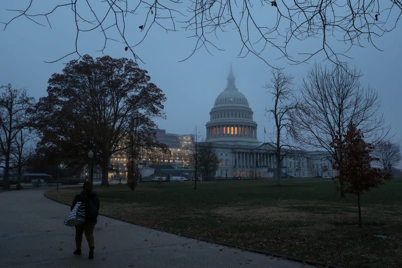 A woman walks past the U.S. Capitol dome early in the morning on Capitol Hill in Washington