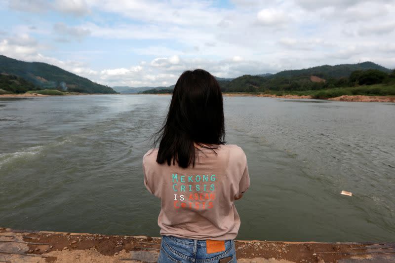 A woman stands next to the Mekong river bordering Thailand and Laos at the Thai side in Nong Khai