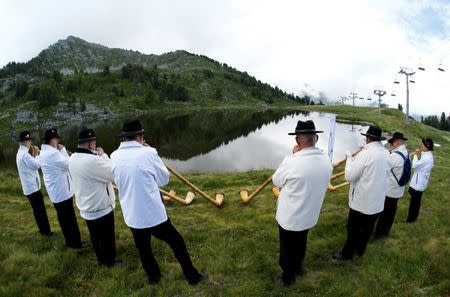 Alphorn blowers perform an ensemble piece on the last day of the Alphorn International Festival on the alp of Tracouet in Nendaz, southern Switzerland, July 22, 2018. REUTERS/Denis Balibouse