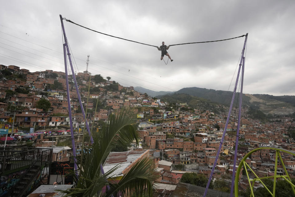 Un turista en una atracción de salto en la Comuna 13, un barrio de Medellín, Colombia, el viernes 2 de febrero de 2024. La ciudad dejó atrás la guerra con los cárteles, pero aún lidia con decenas de pandillas, el tráfico de drogas y la violencia, aún así vive un momento de esplendor turístico. (AP Foto/Fernando Vergara)