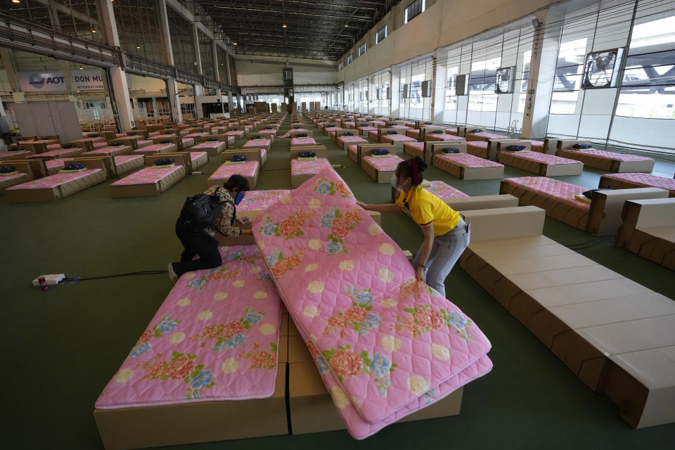 A volunteer and a worker prepare a 1,800-bed field hospital set up inside a cargo building in Don Mueang International Airport in Bangkok, Thailand, Thursday, July 29, 2021. Health authorities raced on Thursday to set up yet another large field hospital in Thailand's capital as the country recorded a new high in COVID-19 cases and deaths. The hospital, one of many already in use, was being set up at one of Bangkok's two international airports after the capital ran out of hospital beds for thousands of infected residents. (AP Photo/Sakchai Lalit)