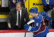 Colorado Avalanche coach Jared Bednar, left, confers with defenseman Cale Makar during a break in play in the third period of Game 3 of the team's NHL hockey Stanley Cup first-round playoff series against the Winnipeg Jets on Friday, April 26, 2024, in Denver. (AP Photo/David Zalubowski)
