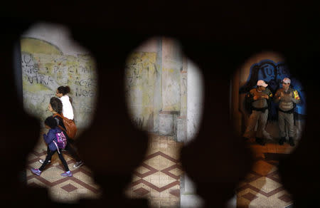 Police officers patrol a street as residents walk in the downtown of Porto Alegre, Brazil September 9, 2018. REUTERS/Diego Vara/File Photo