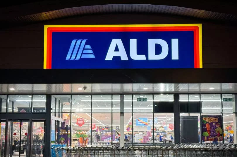Shoppers entering a branch of the budget supermarket retailer Aldi