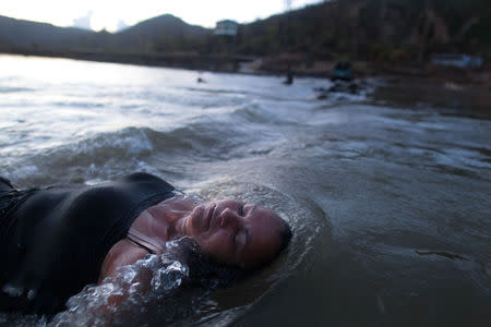 A local resident takes a bath in a river after Hurricane Maria destroyed the town's bridge in San Lorenzo, Morovis, Puerto Rico, October 4, 2017. REUTERS/Alvin Baez