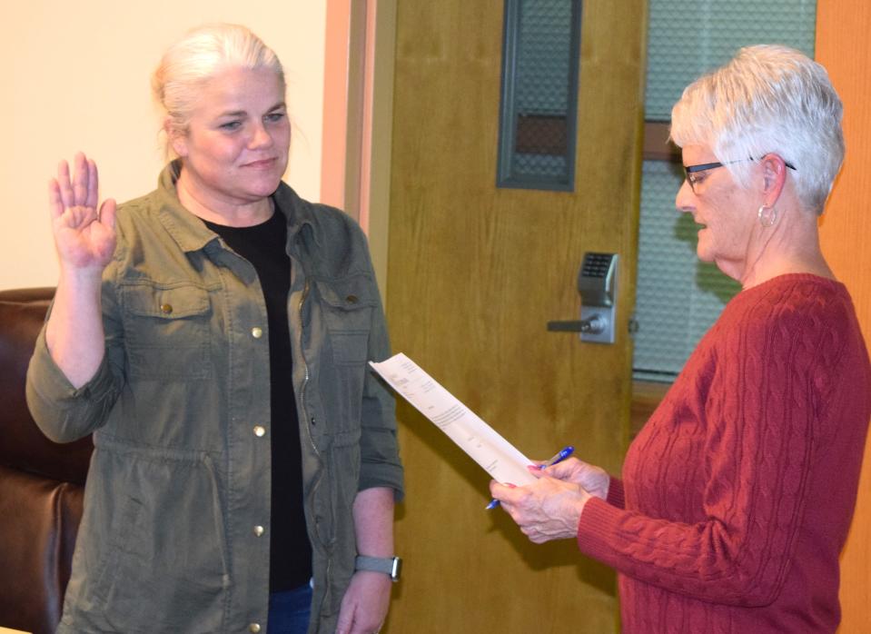 Karen Shafer, retiring village clerk and fiscal officer, swears in her replacement, Bobbie Curry, at Monday's Village Council meeting in Millersburg. Shaffer said worked for the village for 33 years.