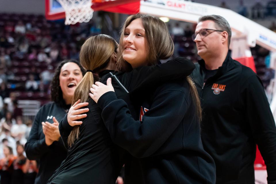 York Suburban assistant coach and 2023 graduate Alyssa Dougherty hugs head coach Jess Waver during the medal ceremony after the Trojans won the District 3 Class 5A girls' basketball championship against Northern York at the Giant Center on March 1, 2024, in Hershey.