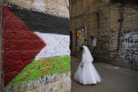 An ultra-Orthodox Jewish girl wearing costume walks next to a wall spray-painted with the Palestinian flag during celebrations of the Jewish holiday of Purim in the Mea Shearim ultra-Orthodox neighborhood of Jerusalem, Sunday, Feb. 28, 2021. The Jewish holiday of Purim commemorates the Jews' salvation from genocide in ancient Persia, as recounted in the biblical Book of Esther. (AP Photo/Oded Balilty)