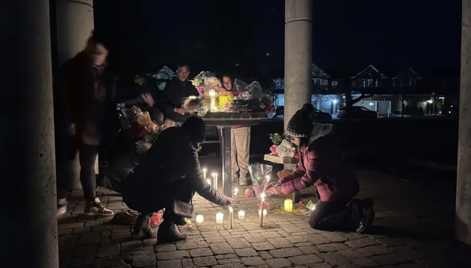 People lay flowers and light candles at a park near the crime scene at Berrigan Drive in Ottawa on March 7, 2024. (Marina von Stackelberg/CBC)