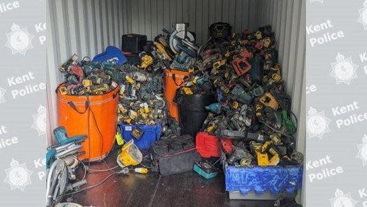 A pile of power tools in what looks like a shipping container