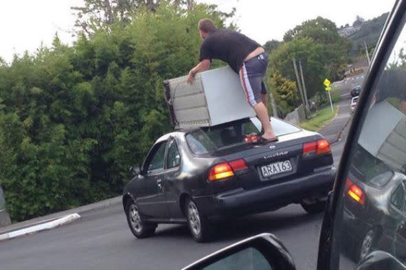New Zealanders transport fridge on top of car