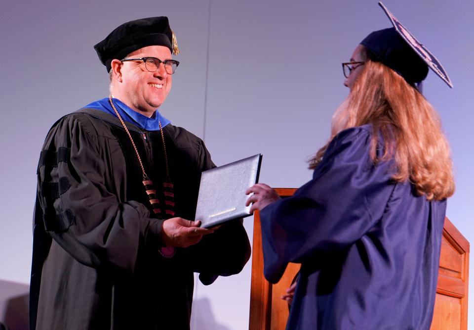 Carl Sandburg College President Seamus Reilly awards a diploma during the college's 54th Commencement on May 19 in Galesburg.